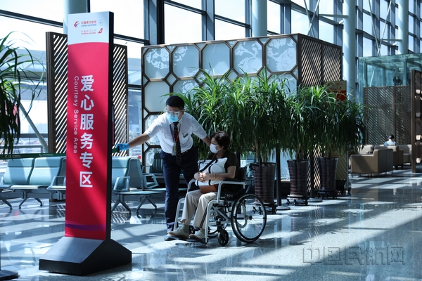 nEO_IMG_4.东航地服人员正在向旅客介绍爱心服务专区里的服务内容.jpg